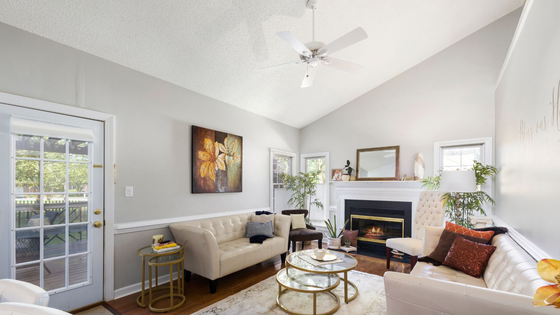 Cozy living room with fireplace, white sofas, and floral artwork