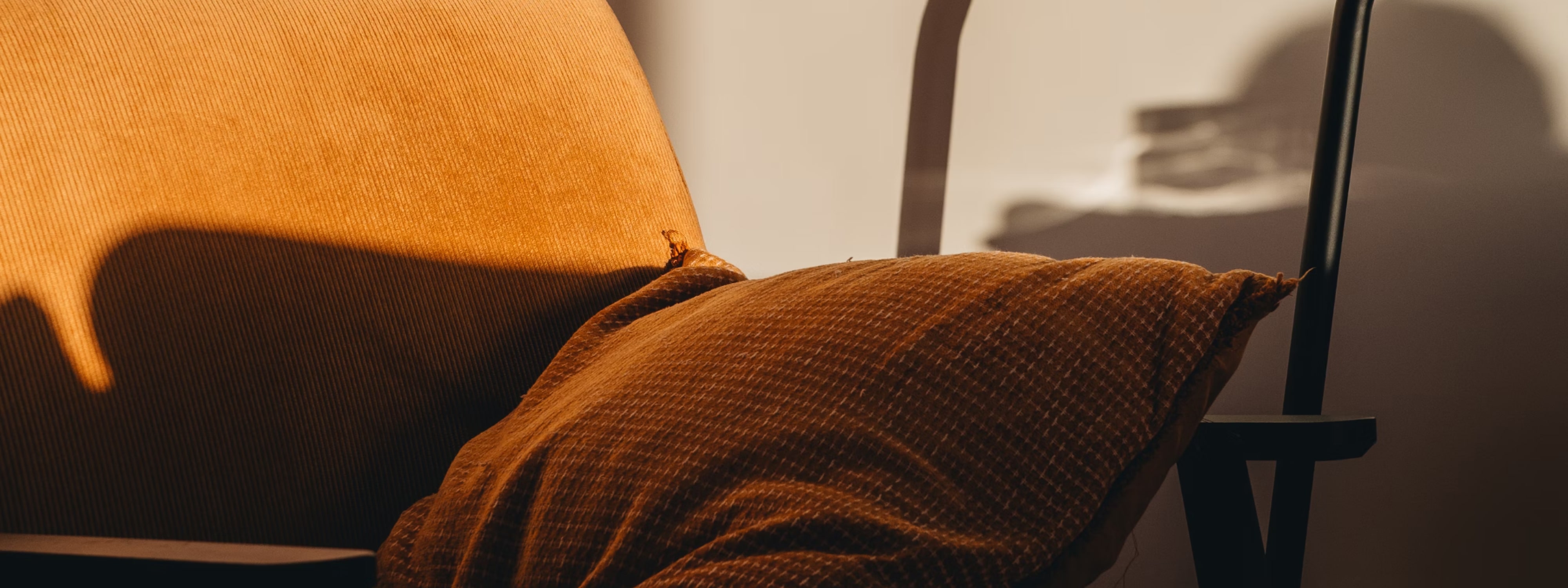 Warm orange fabric draped over a chair with soft shadows